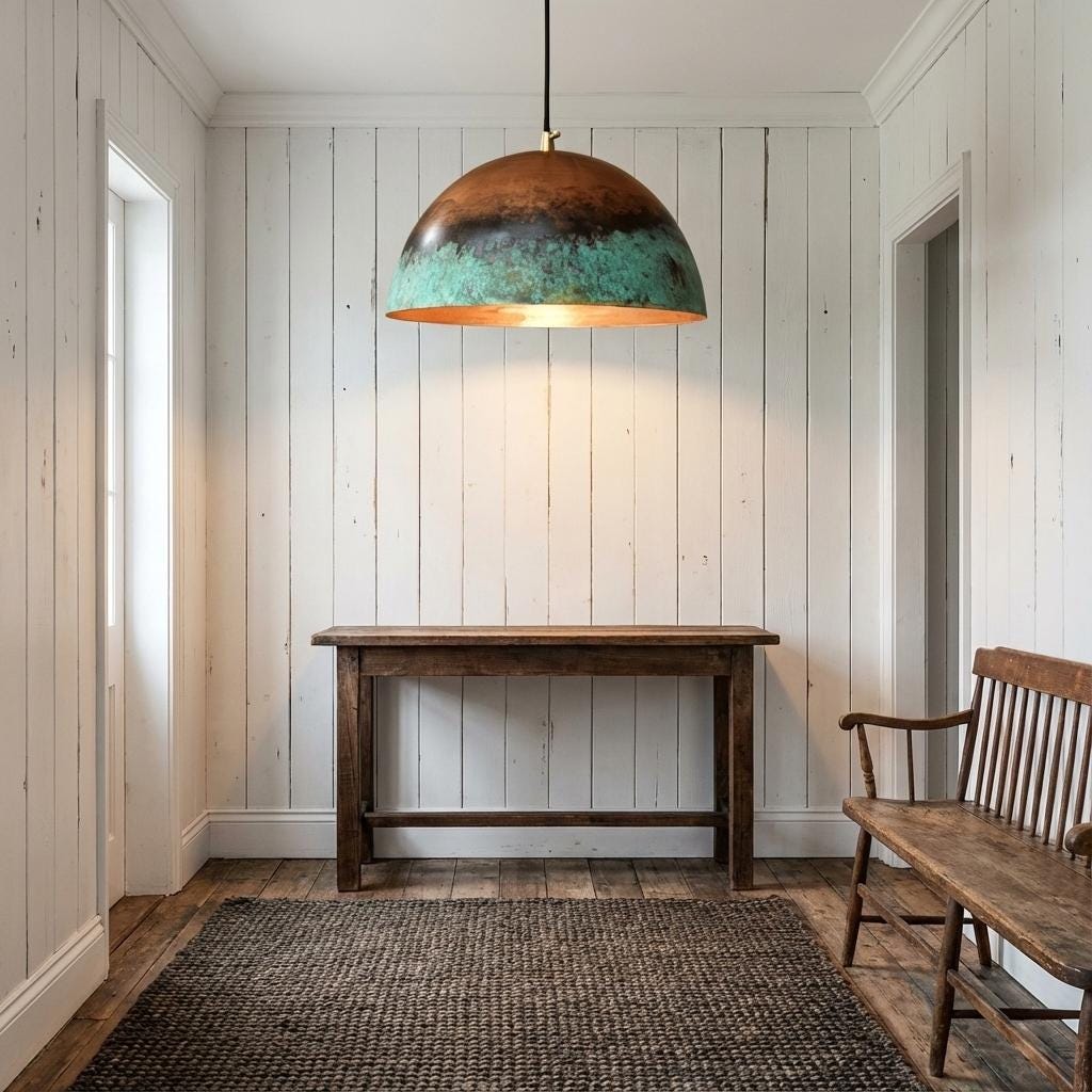 Narrow hallway with wooden table, bench, and pendant light against white paneled walls.
