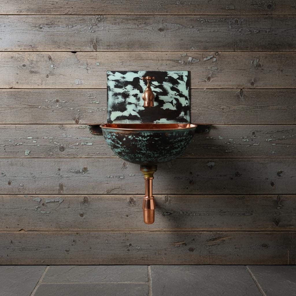 Wall-mounted copper sink with greenish-blue basin against a wooden wall.