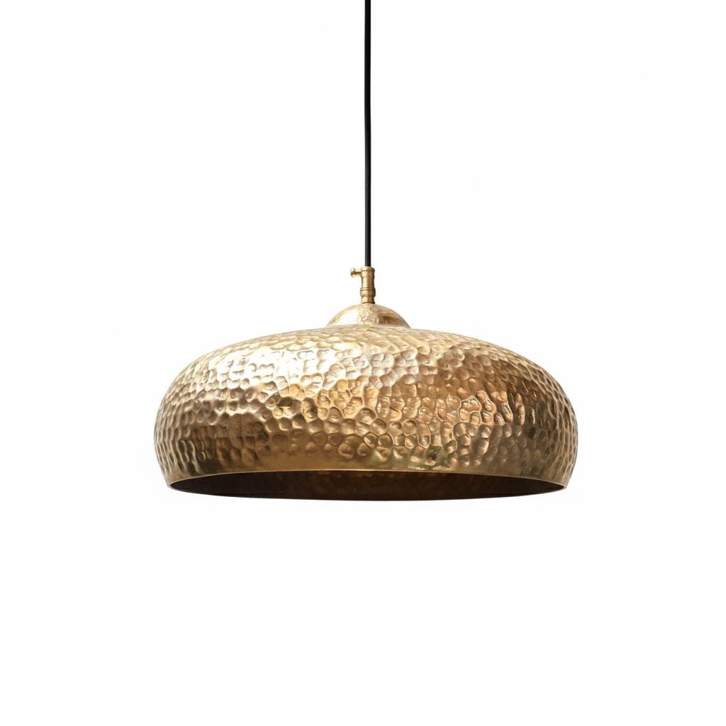 Gold pendant light with a textured surface on a white background