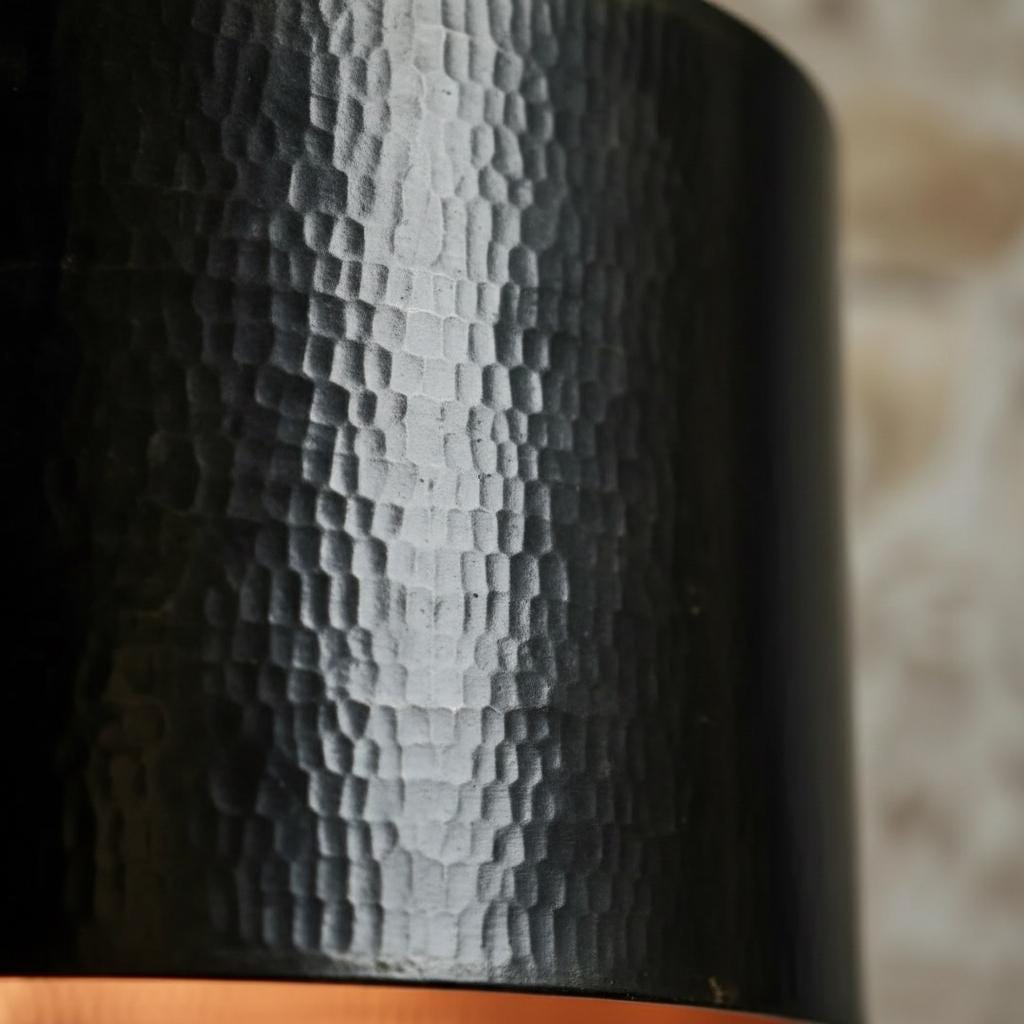 Close-up of a textured black bottle on a wooden surface with a blurred background