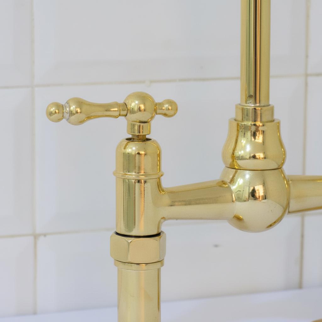 Gold faucet against a tiled wall background