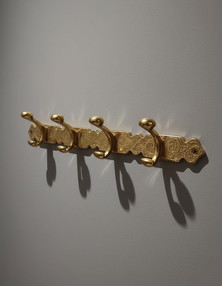 Gold decorative wall hook on a gray background