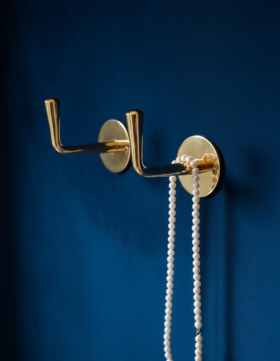 Gold wall hook with a necklace on a blue background