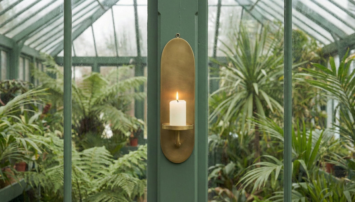 Decorative wall sconce with a candle inside a greenhouse