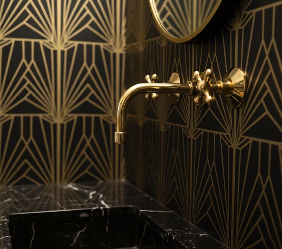 Gold faucet on a black marble sink with geometric gold wall patterns
