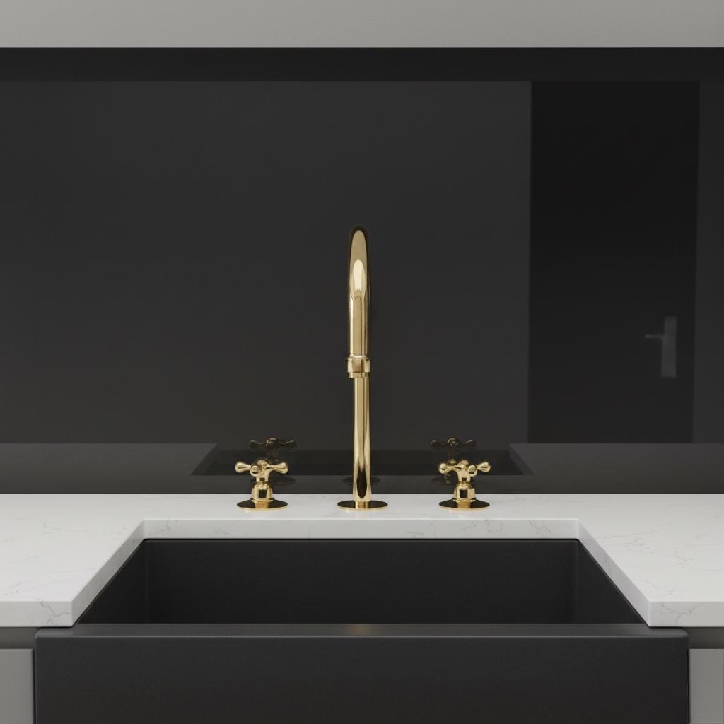 Gold faucet and handles on a black sink with a dark gray wall background