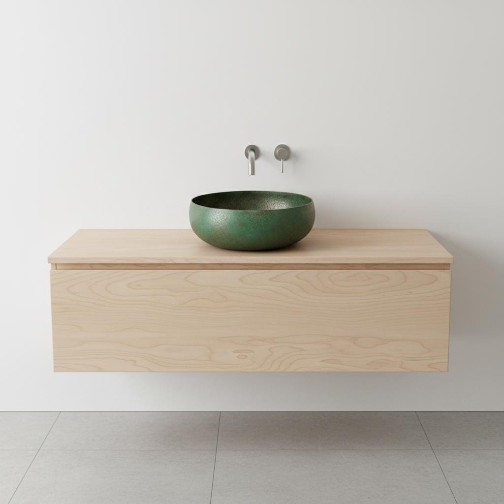 Green sink on a wooden vanity against a white wall