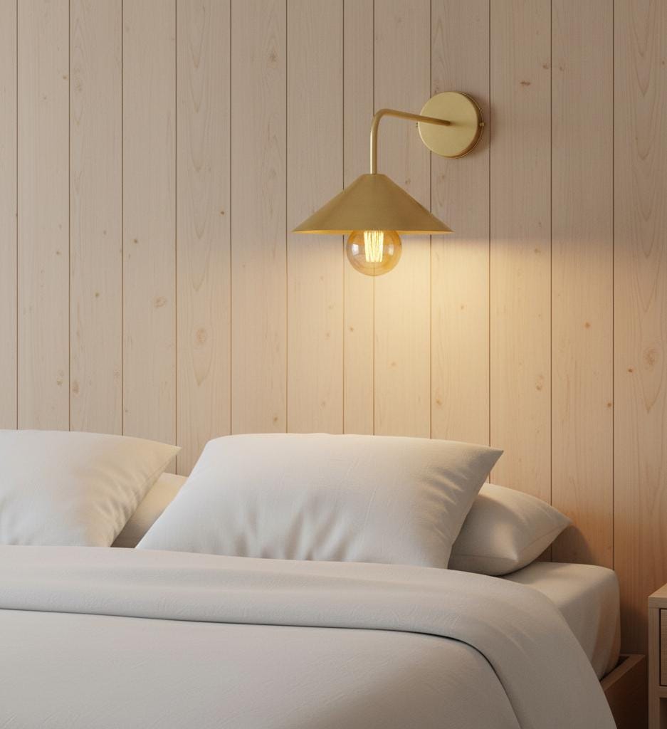 Bedroom with a gold wall lamp on a wooden paneled wall