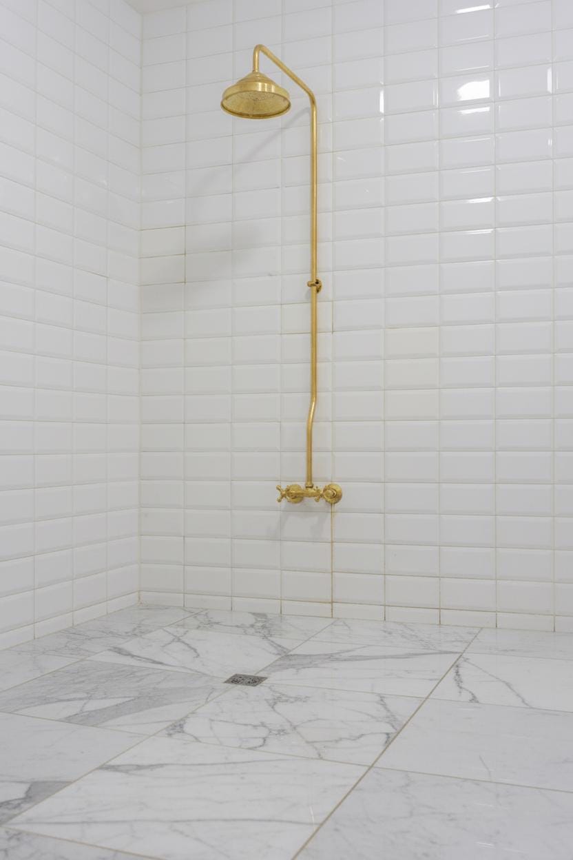 Shower setup with gold fixtures in a tiled bathroom