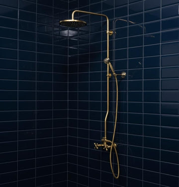 Gold shower set against a dark blue tiled wall