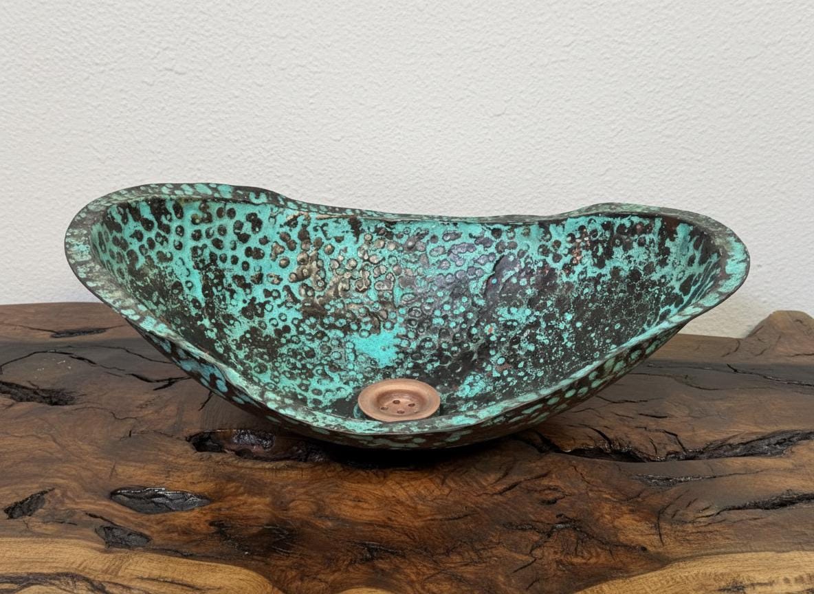 Decorative glass bowl with a green and brown speckled pattern on a wooden surface.