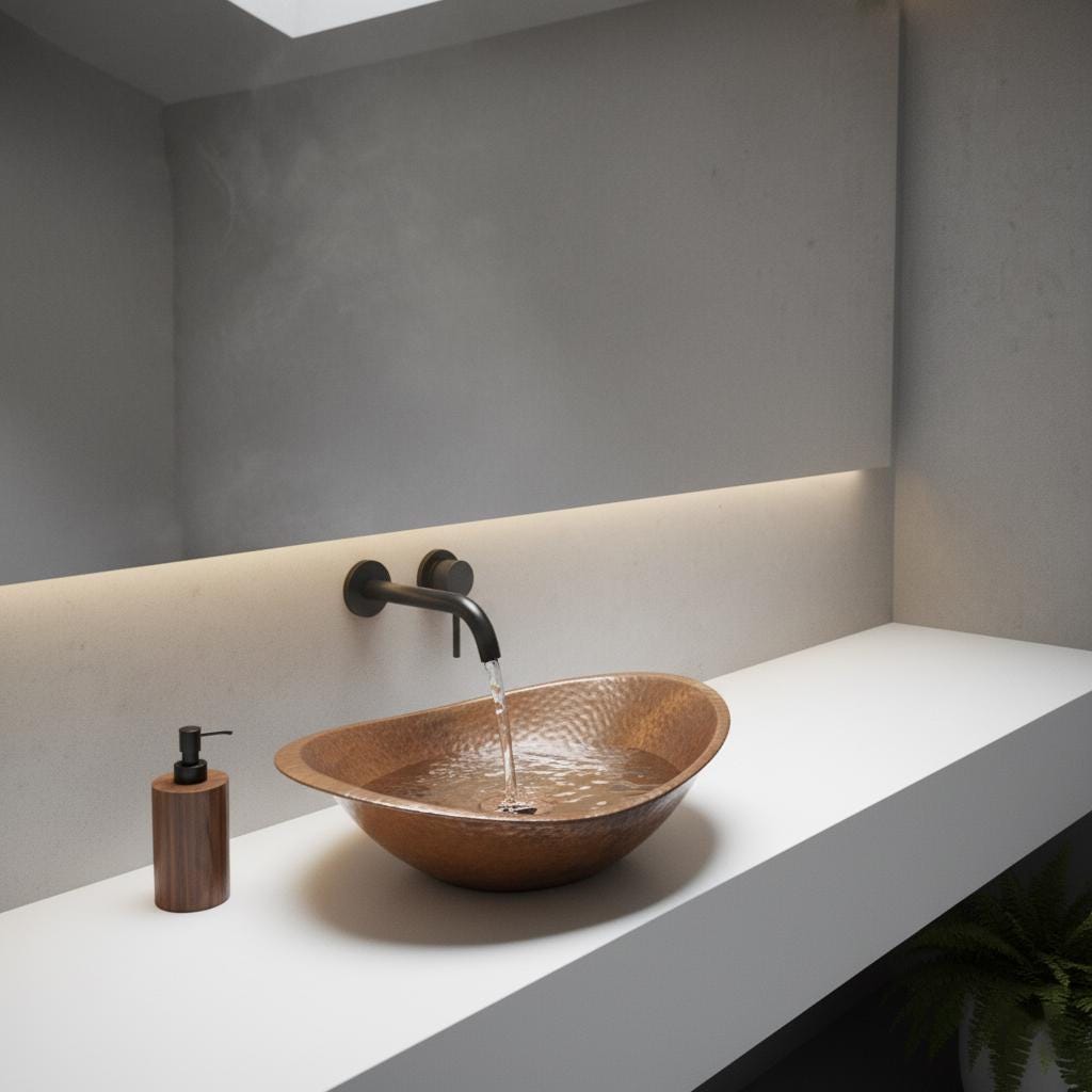 Bathroom sink with bronze basin and black faucet against a gray wall.