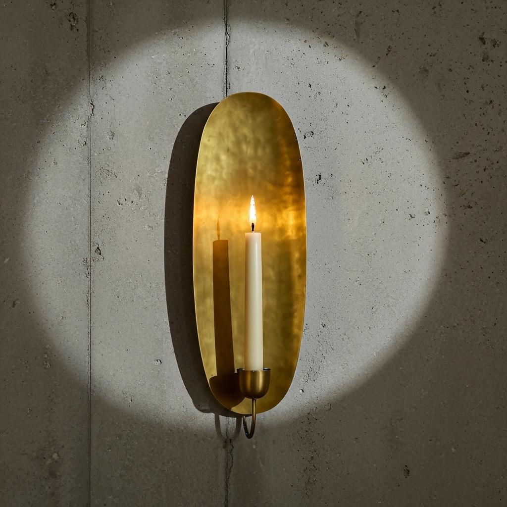 Brass wall sconce with a candle on a textured wall