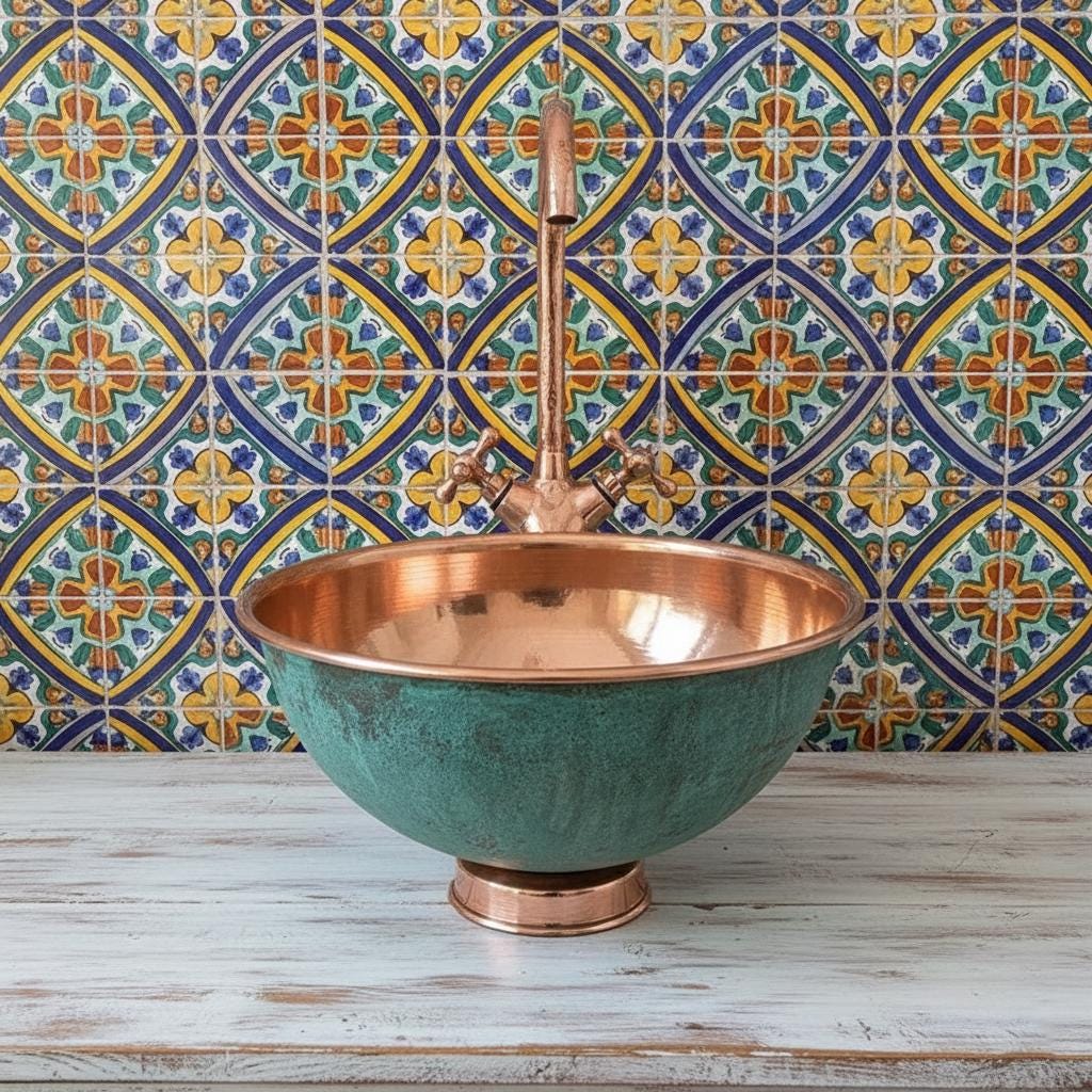 Copper sink with a decorative tiled wall in the background