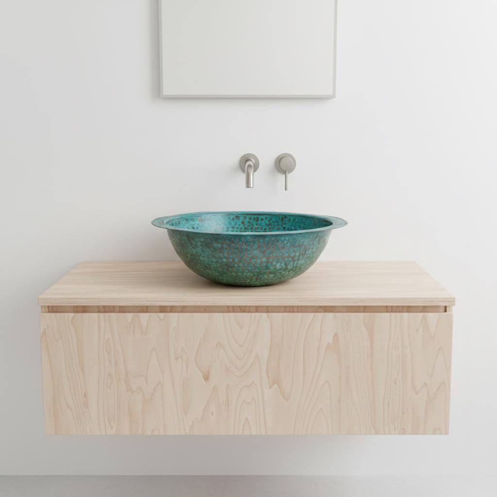 Bathroom vanity with a teal ceramic sink and silver faucet against a white wall.