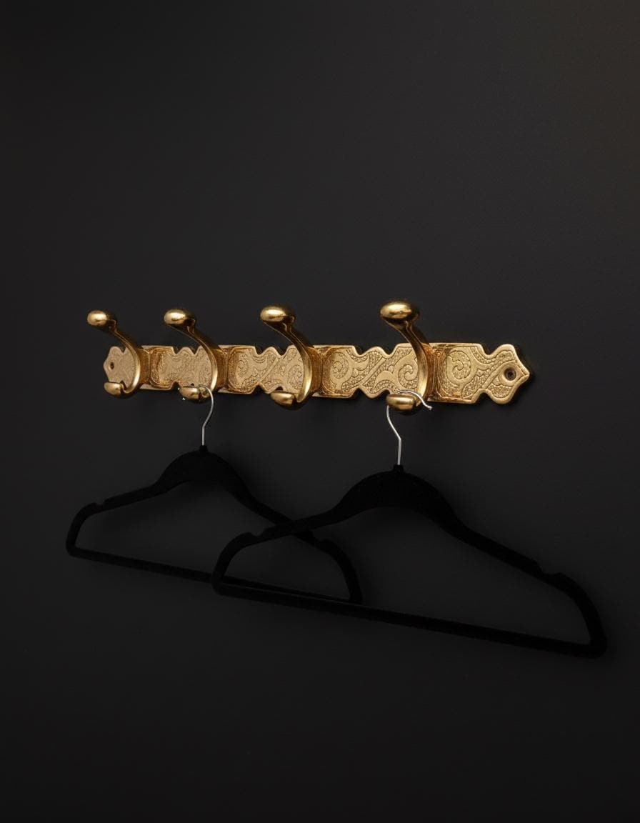 Gold decorative coat rack with hooks on a black background