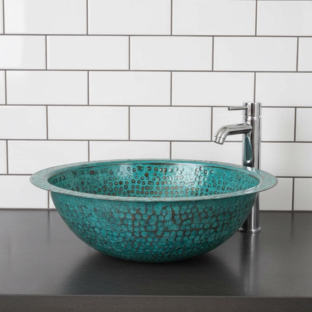 Turquoise mosaic sink with silver faucet against a white tiled wall.