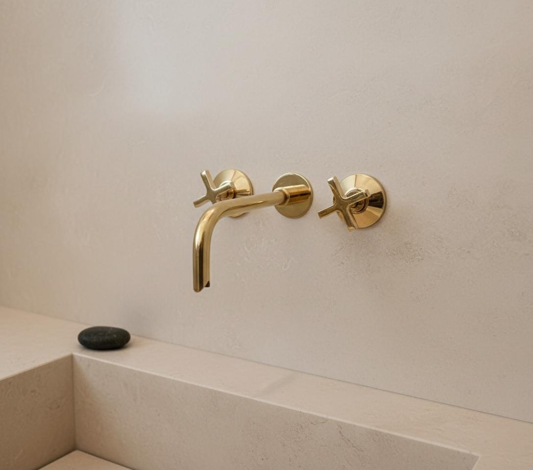 Gold faucet and handles on a white wall
