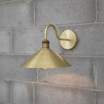 Brass wall sconce on a gray brick wall