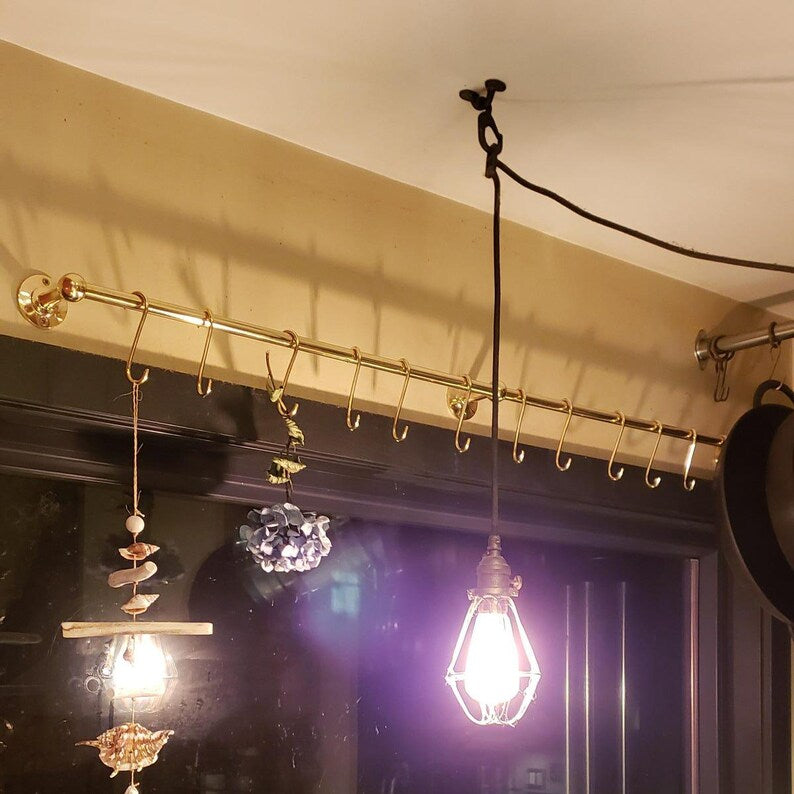 Handmade brass kitchen organizer with multiple hooks for hanging cookware

