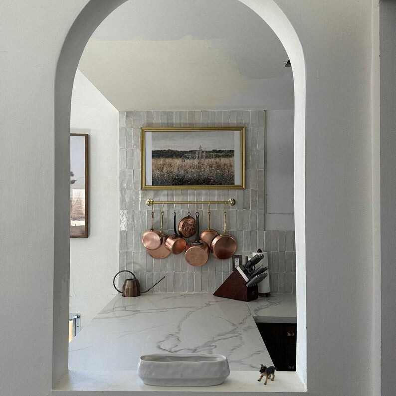 Moroccan unlacquered brass kitchen rail rack with hooks mounted on rustic white wall
