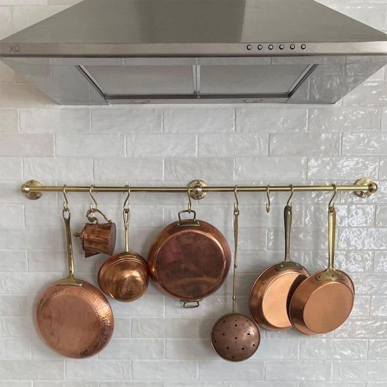 Handmade brass kitchen organizer with multiple hooks for hanging cookware

