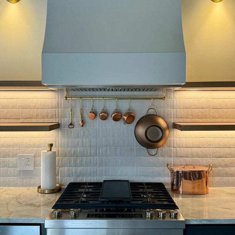 Unlacquered brass rail rack used to hang measuring cups, herbs, and utensils

