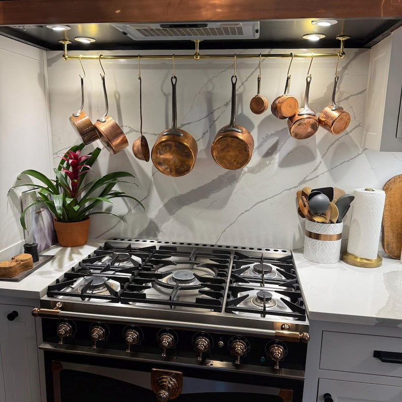 Unlacquered brass rail rack used to hang measuring cups, herbs, and utensils

